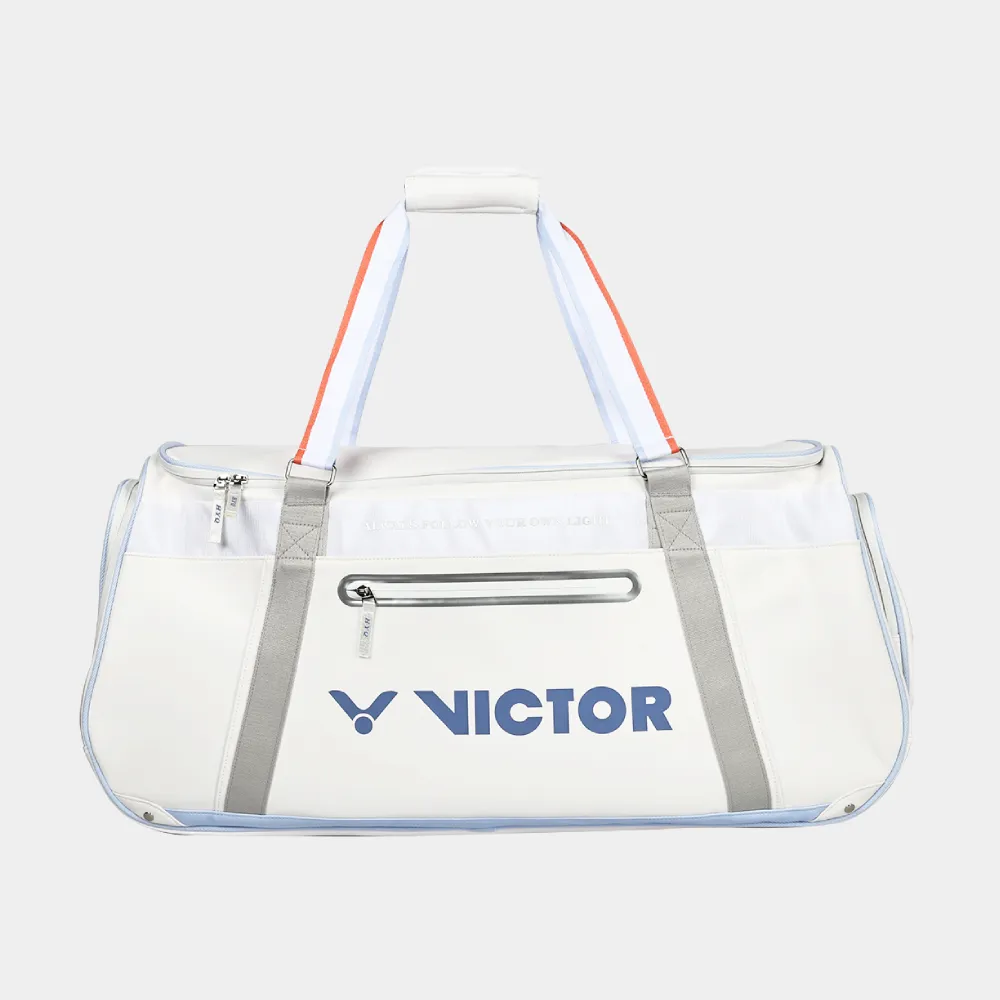 Cận cảnh ngăn trước túi vợt Victor BR5681HYQ 2.0, logo VICTOR chữ lớn màu xanh dương, khóa kéo ngang có tay kéo kim loại, viền xanh pastel, quai đeo vai xám vắt ngang thân túi