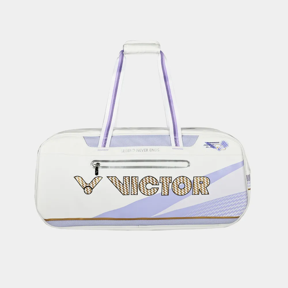 Mặt sau túi cầu lông Victor BR5680ZSW 2.0 màu trắng, logo VICTOR chữ lớn viền đồng vàng, ngăn khóa kéo ngang in dòng chữ Legend Never Ends, huy hiệu quả cầu lông ở góc phải, dải tím pastel chạy chéo