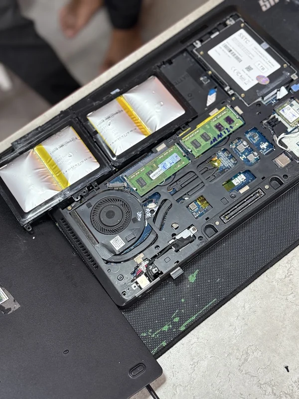 Kỹ thuật viên mở nắp laptop kiểm tra pin, RAM, quạt tản nhiệt và ổ SSD