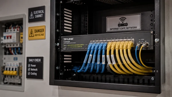 Tủ điện và switch mạng gắn tường trong phòng máy quán net
