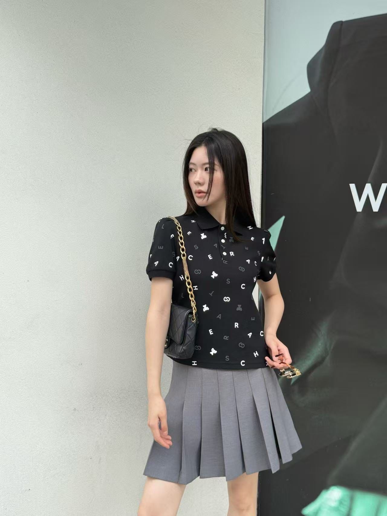  Áo polo đen, họa tiết chữ, gấu trắng 