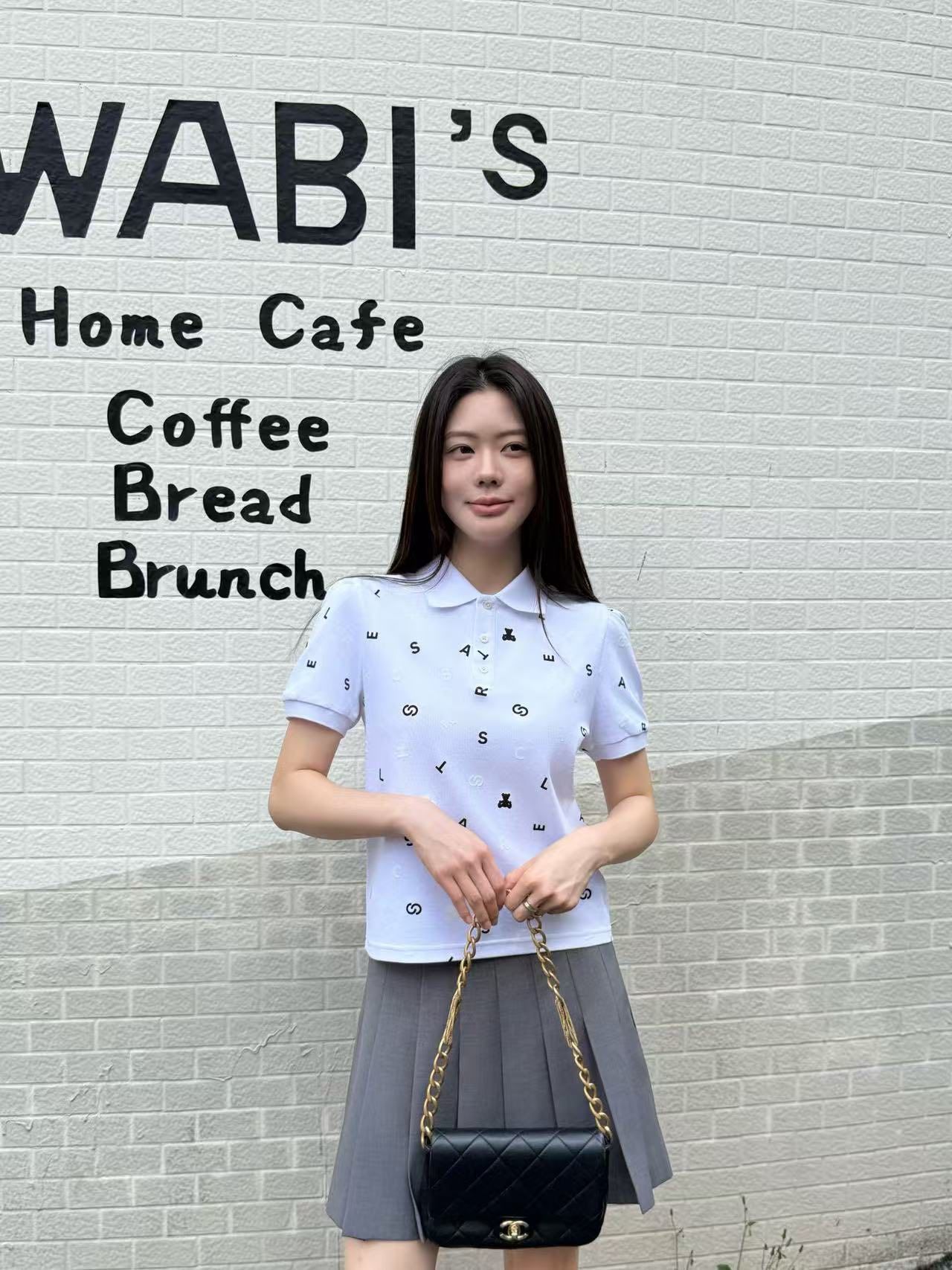  1.Áo polo trắng, họa tiết chữ, gấu đen 