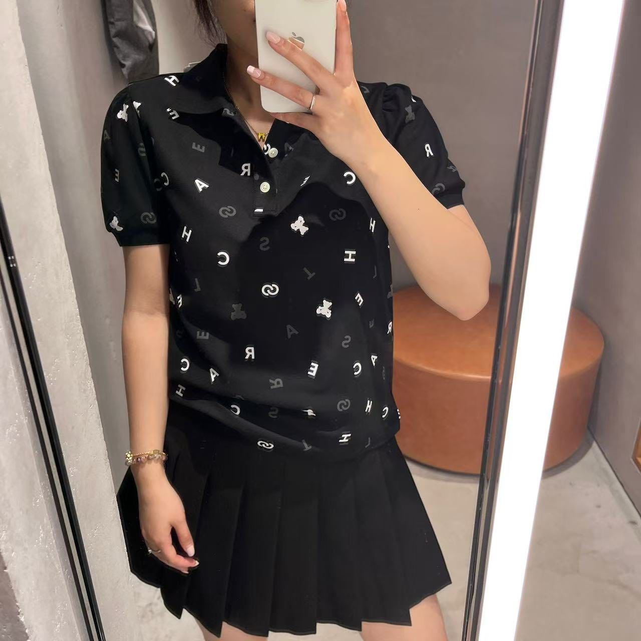  Áo polo đen, họa tiết chữ, gấu trắng 