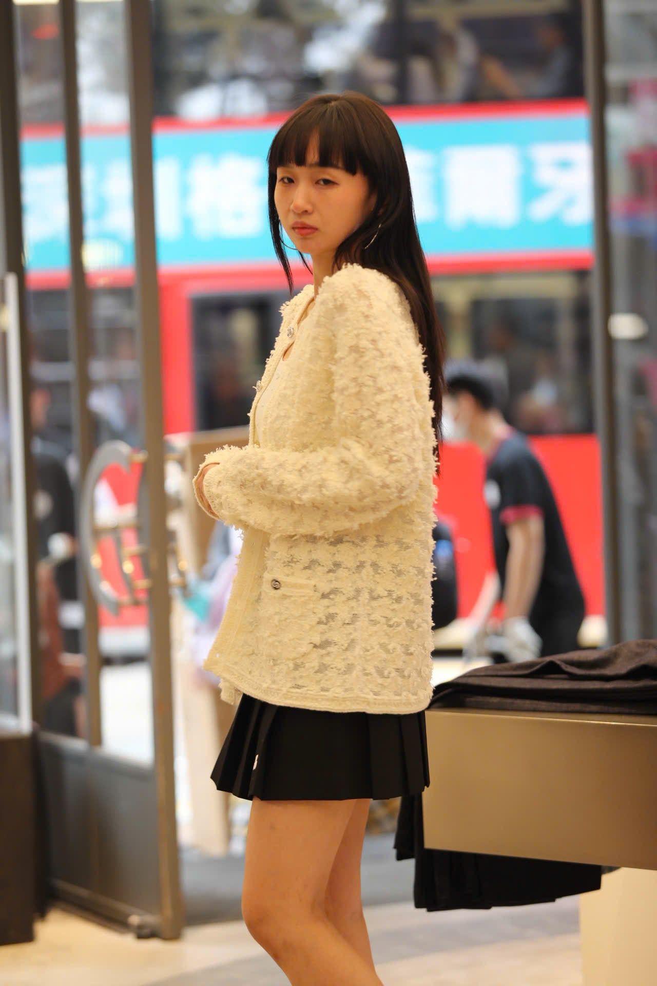  6.Chân váy ngắn xếp ly đen, gấu trắng, cạp chữ chạy 