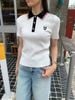  Áo polo trắng cổ đen sọc đỏ ,logo huy hiệu 