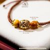  Vòng Tay Thắt Dây Mắt Hổ Vàng 8mm 5A Phối Charm Tam Thánh Pháp Luân 