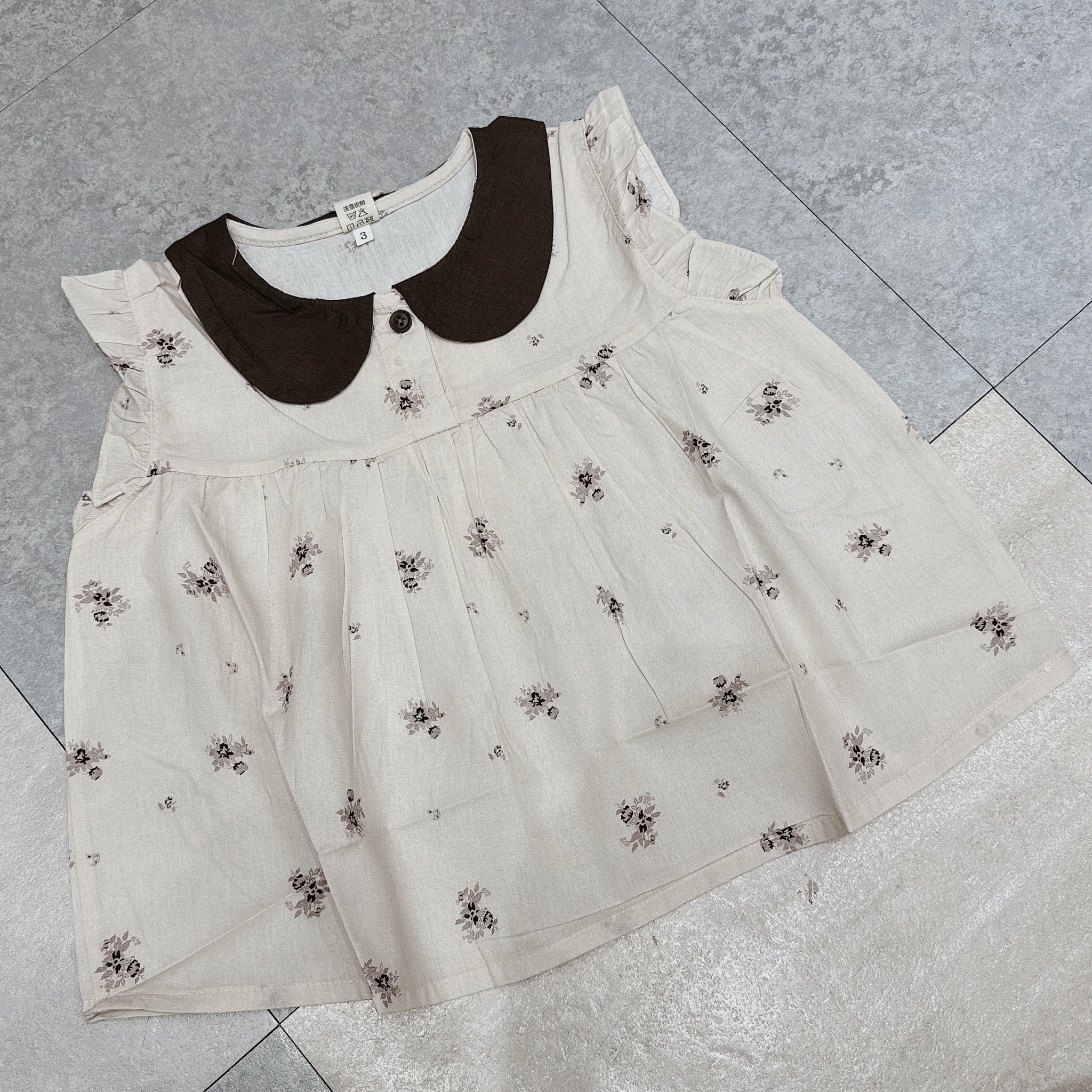 99099 - Áo sơ mi thô đũi cổ sen màu be hoa nhí ghi bé gái size 90-130