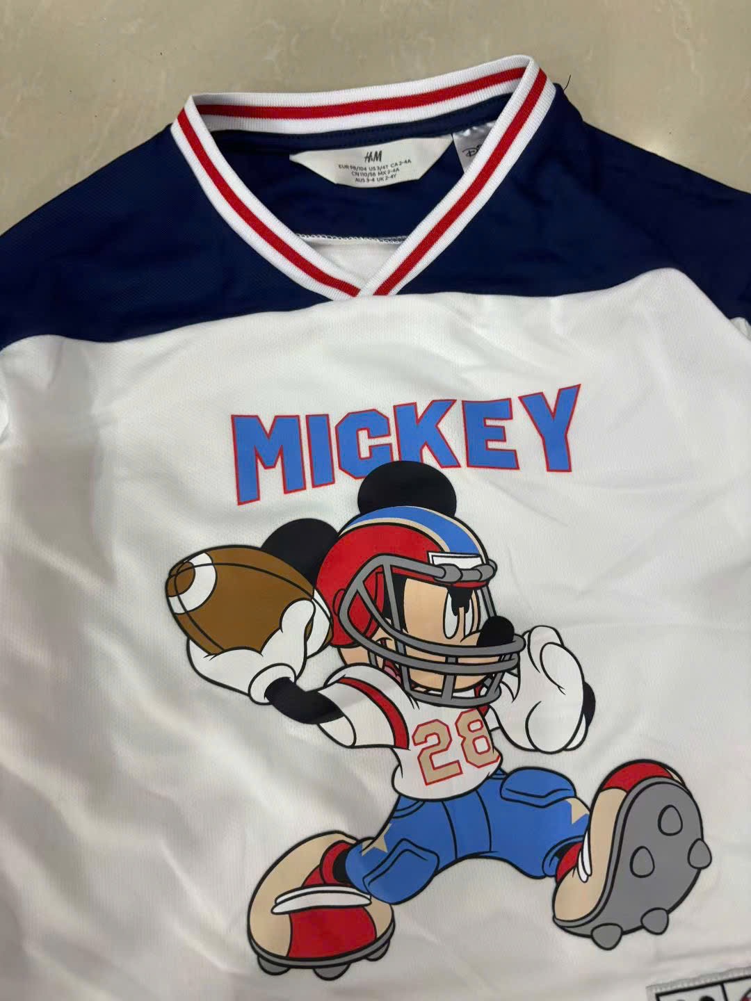 Áo thun thể thao H M màu trắng Mickey bóng bầu dục cho bé size