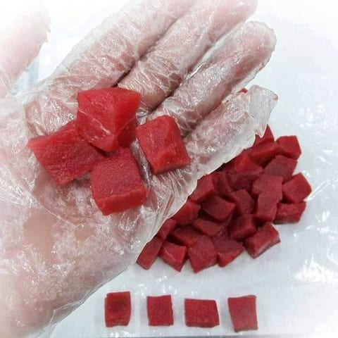 Thịt cá ngừ cắt hạt lựu đỏ tươi trên tay