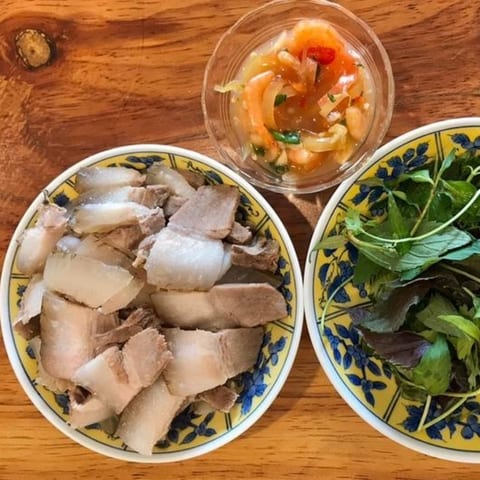 Đĩa thịt ba rọi heo rừng luộc ăn kèm mắm tôm và rau sống