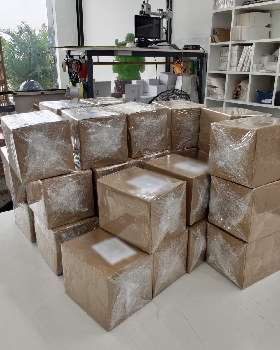 Nhiều thùng carton đã đóng gói, quấn màng, xếp chồng trong xưởng The Muse chờ giao